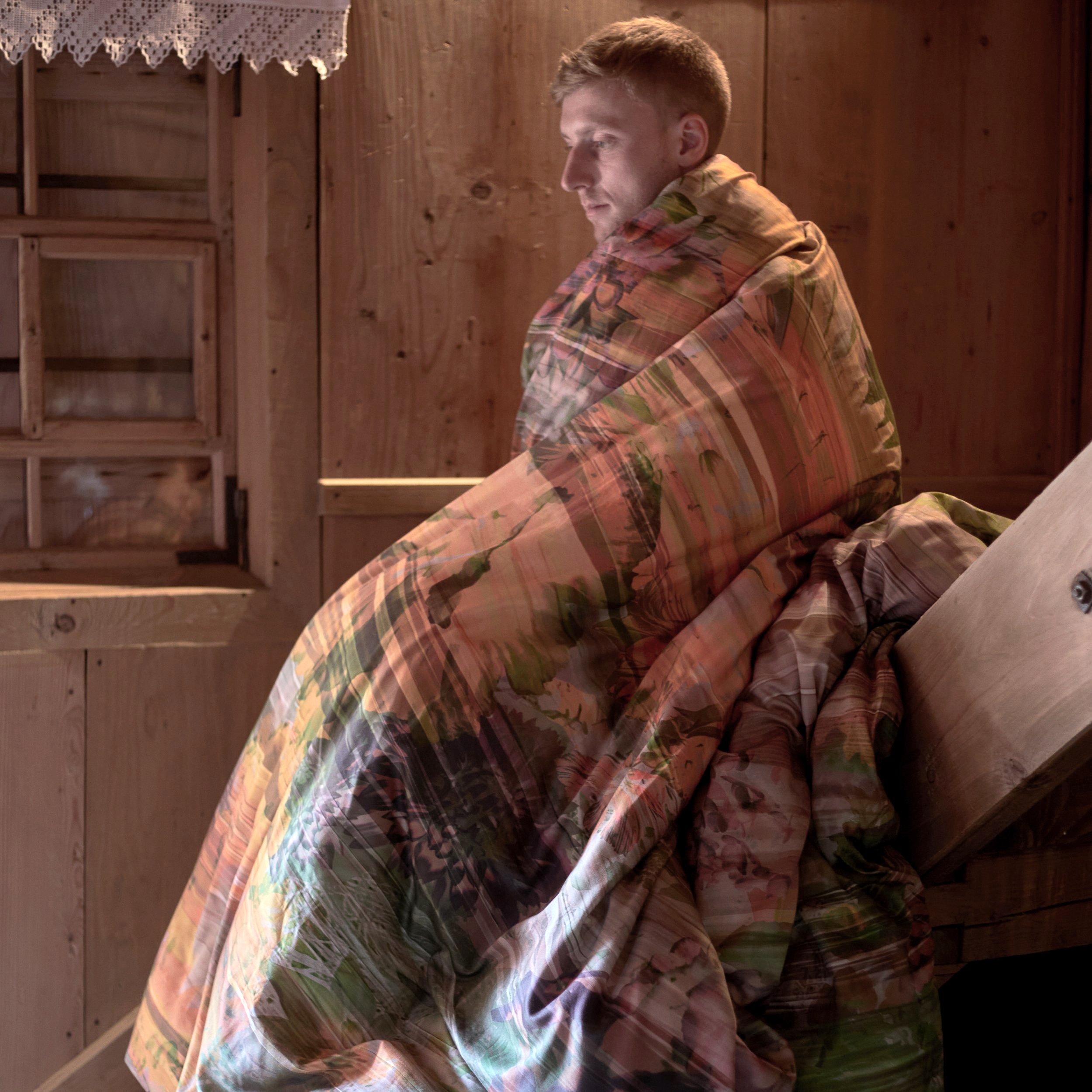 man in duvet on stairs